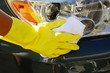 Foto: Woman's hand with a rag washing headlights of an SUV car Woman's hand with a rag washing headlights of an SUV car