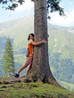 girl hugging a tree in mountains