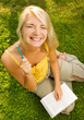 Funny wide angle portrait of a young woman reading book outdoors