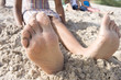 Close-up of woman's barefeet in sand at beach