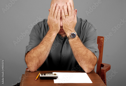 Photo: Man showing signs of stress while working budget Man showing signs of stress while working budget