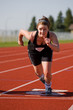 A female athlete launching off the start line in race