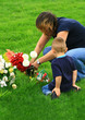 woman and child putting flowers on grave