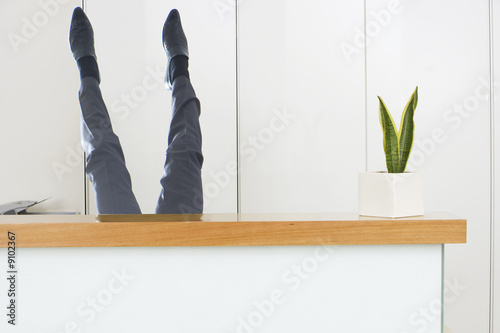 Photo: Businessman upside-down behind desk Businessman upside-down behind desk