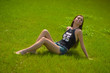 The beauty wet brunette on the grass under the fountain splashes The beauty wet brunette on the grass under the fountain splashes
