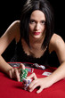 Determined attractive brunette playing cards at a red poker Determined attractive brunette playing cards at a red poker