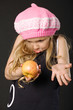 funny surprised little girl with apple on black background