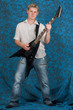 A young guitar player on a blue background playing the guitar