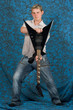 A young guitar player on a blue background holding the guitar