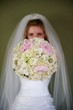 An image of a bride holding out her bouquet