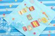 cut out letters spelling it's a party on baby blue napkins