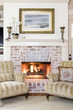 matching chairs in front of lit fireplace
