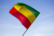 Red, yellow, green reggae flag over blue sky Red, yellow, green reggae flag over blue sky
