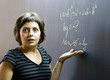 Teacher writing math formulas on blackboard