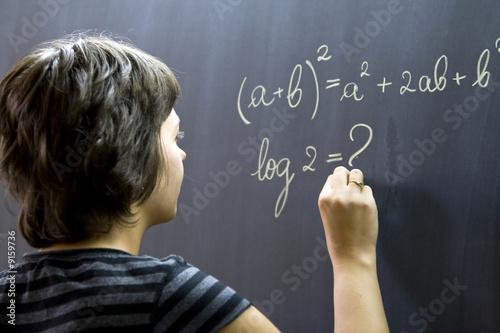 Teacher writing math formulas on blackboard