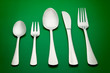 arrangement of table silverware over green background