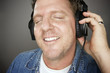 Man Wearing Headphones Enjoying His Music on a Grey Background. Man Wearing Headphones Enjoying His Music on a Grey Background.