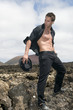 stressed but sexy man on the lava of a vulcan under the sky