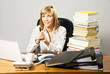 Photo: Young beautiful business lady working at a busy desk. Young beautiful business lady working at a busy desk.