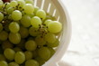 White bowl full of green grapes, copy space on right..