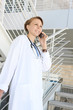 A young, pretty woman nurse at hospital building on stairs
