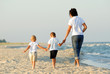 Three people walking on beach
