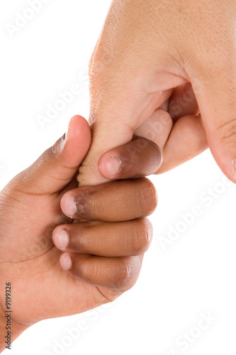 Photo: Two hands of different races together on a white background Two hands of different races together on a white background