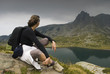 Resting mountaineer sitting on a rock