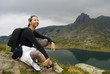 Resting mountaineer sitting on a rock