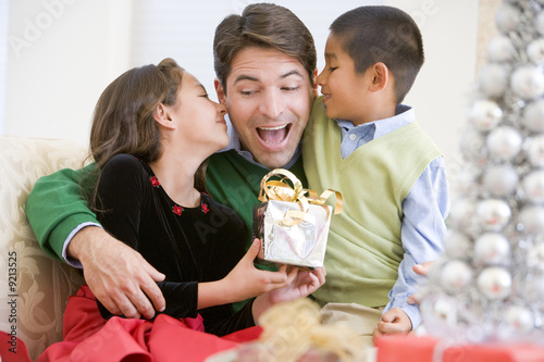 Foto: Father Being Given A Christmas Present By His Daughter And Son Father Being Given A Christmas Present By His Daughter And Son