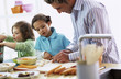 Father with children (4-7) preparing meal