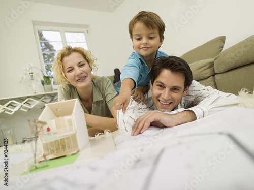 Foto: Young family in living room, smiling Young family in living room, smiling
