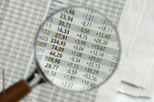 Photo: Stock quotations under magnifying glass, close-up Stock quotations under magnifying glass, close-up