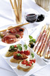 Grissini with parma ham and olives and mozzarella with tomatoes, italian starters