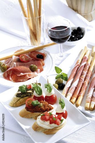 Photo: Grissini mit Parmaschinken und Oliven und Mozzarella mit Tomaten, italienische Vorspeisen Grissini mit Parmaschinken und Oliven und Mozzarella mit Tomaten, italienische Vorspeisen