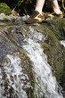 Young woman crossing stream, low section