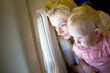 mother and child look through the window of the airplane mother and child look through the window of the airplane