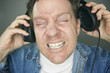 Shocked Man Desperately Trying To Take Off Headphones Shocked Man Desperately Trying To Take Off Headphones