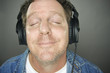 Man With Headphones Enjoys Music - Grey Background. Man With Headphones Enjoys Music - Grey Background.