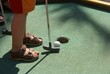 putting a ball into a hole of crazy golf