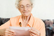 Photo: eine seniorin öffnet freudig einen briefumschlag eine seniorin öffnet freudig einen briefumschlag