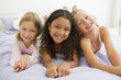 Photo: Three Young Girls Lying On A Bed In Their Pajamas Three Young Girls Lying On A Bed In Their Pajamas