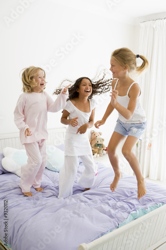 Photo: Three Young Girls Jumping On A Bed In Their Pajamas Three Young Girls Jumping On A Bed In Their Pajamas
