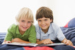Photo: Two Young Boys Lying Down On A Bed Reading A Book Two Young Boys Lying Down On A Bed Reading A Book
