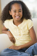 Young Girl Sitting On A Sofa At Home