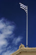 greek flag on top of the parliament building in athens