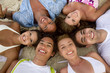 Happy group of friends at the beach smiling with their heads