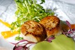 An image of gourmet seared scallops with garnishes