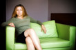 Beautiful young woman on green leather couch