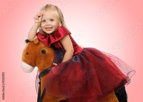 Photo: Portrait of the beautiful girl on a toy horse Portrait of the beautiful girl on a toy horse